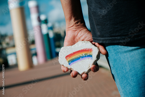 man has a rock with a rainbow flag in his hand photo