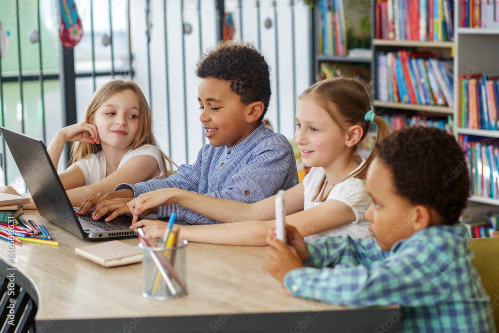 Obraz premium Multiracial group of children sitting in row at school classroom and using laptops. Back to school.