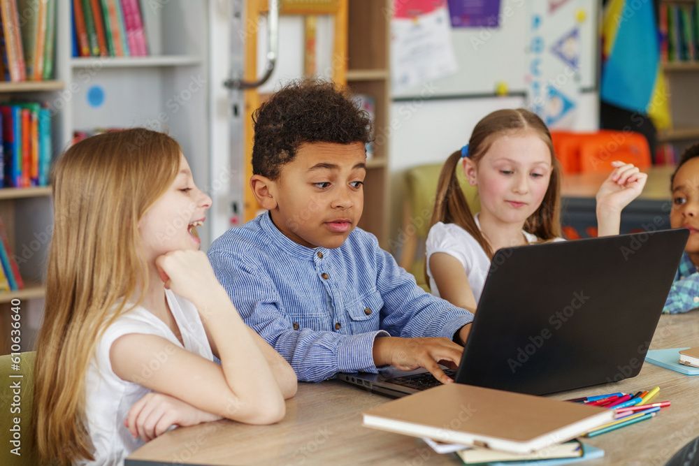Multiracial group of children sitting in row at school classroom and using laptops. Back to school. Multiracial group of children sitting in row at school classroom and using laptops. Back to school.