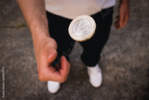 Münzwurf mit ein Euro Münze auf Stein photo