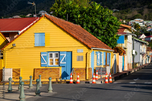 Street view panorama of picturesque creole village “Les Anses-d'Arlet“ with colorful wooden houses and tropical vegetation. Idyllic popular holiday destination on caribbean island Martinique, France. photo