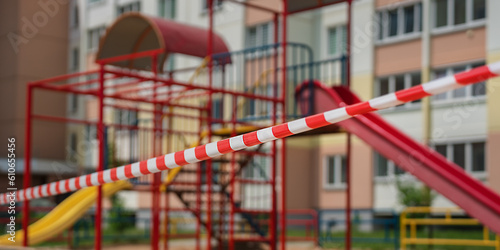 Empty playground in courtyard fenced with red and white attention tape for children safety