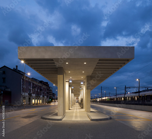 Modern bus stop shelter in Mendrisio. There is a long, lighted corridor with several stops.