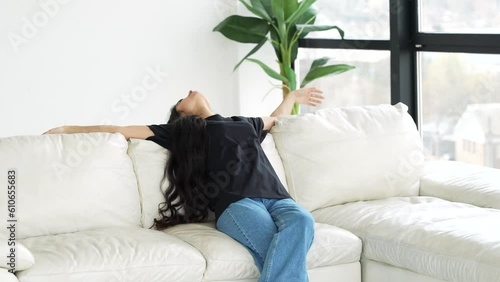 Fatigue after work. Tired young woman comes home and plops down on the couch.