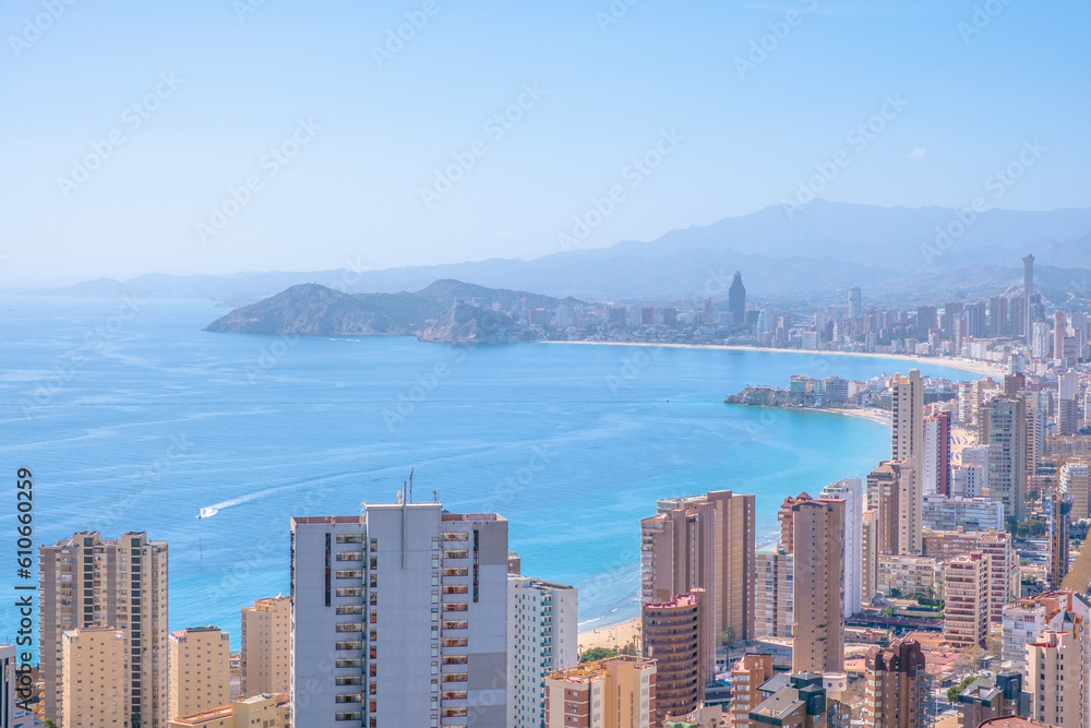 Panorama of famous Benidorm resort city. Coast of Mediterranean sea, Benidorm skyscrapers, hotels and blue sky and mountains in the background. Alicante province, Spain
