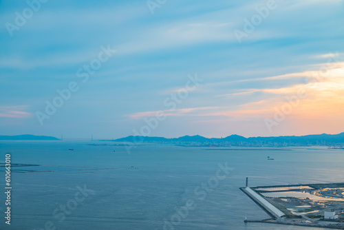 【大阪から撮影】夕暮れ時の瀬戸内海の写真で遠くの方に明石海峡大橋が見える。 © suzume