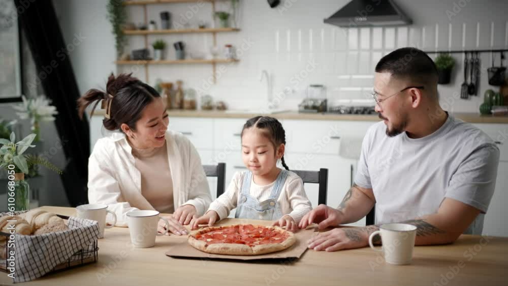 Asian Family Eating Pizza. Mom Dad and Daughter are ready to enjoy pizza delivery service. Happy family time. Asian Family Eating Pizza. Mom Dad and Daughter are ready to enjoy pizza delivery service. Happy family time.