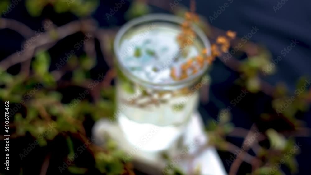 Cinematic shot of tulsi or basil leaf extract in a glass along with fresh basil leaves beside it on a wooden surface, Dolly shot of holy basil (Ocimum basilicum) HD footage 24FPS. Cinematic shot of tulsi or basil leaf extract in a glass along with fresh basil leaves beside it on a wooden surface, Dolly shot of holy basil (Ocimum basilicum) HD footage 24FPS.