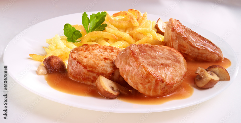 Schweinefilet mit Schupfnudeln auf weissem Teller Schweinefilet mit Schupfnudeln auf weissem Teller