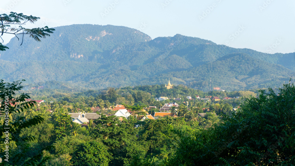 Landscape of mountains with a view on a buddhist temple made of gold in Luang Prabang, Laos