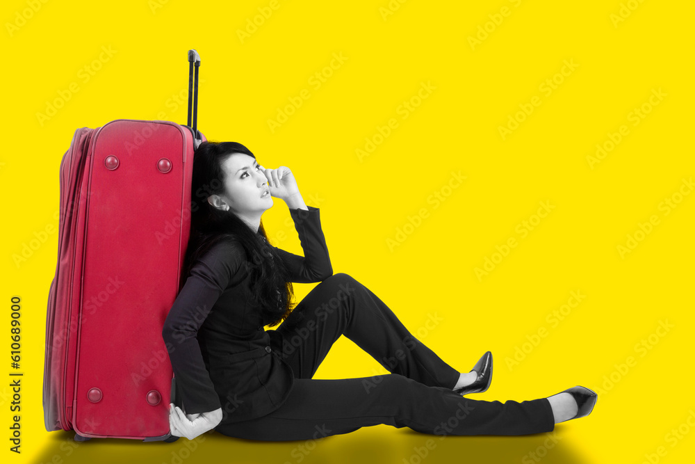 Businesswoman sitting on the floor with a suitcase Businesswoman sitting on the floor with a suitcase