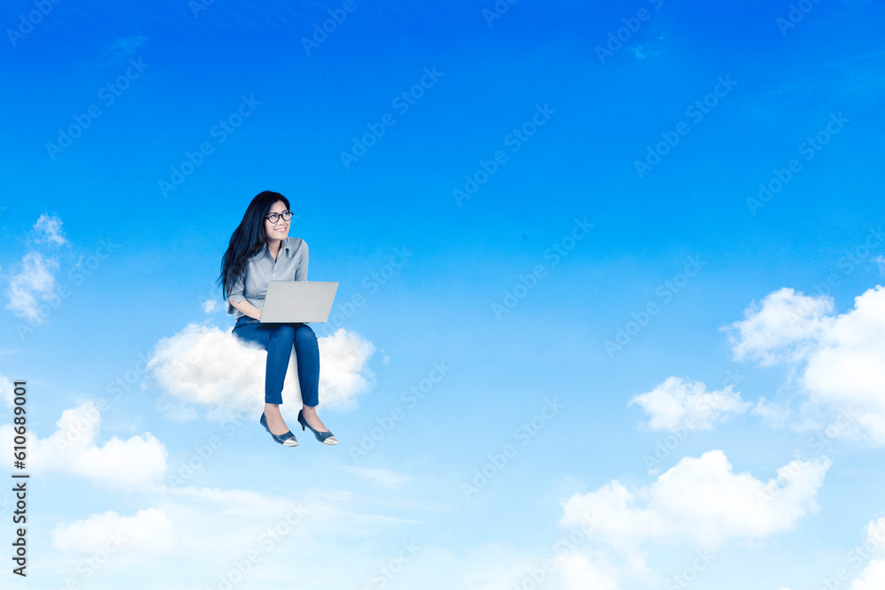 Girl working on computer laptop sitting on clouds over blue sky Girl working on computer laptop sitting on clouds over blue sky