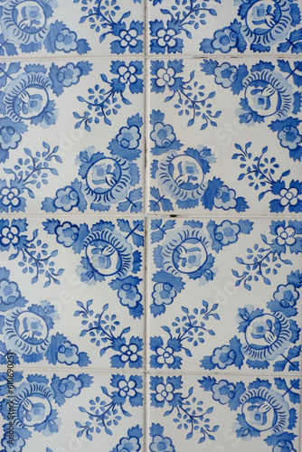 Vintage tiles of blue colour with rustic floral ornate downtown in Porto, Portugal. Traditional portuguese tiling. Tiled wall, vertical photo