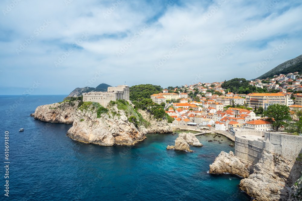 Amazing panoramic view of the famous city of Dubrovnik in Croatia, old town with city walls, houses with red roofs, historical buildings surrounded by turquoise sea