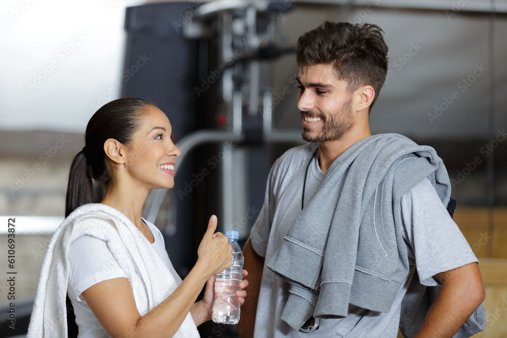 young couple chatting while taking a rest in the gym young couple chatting while taking a rest in the gym
