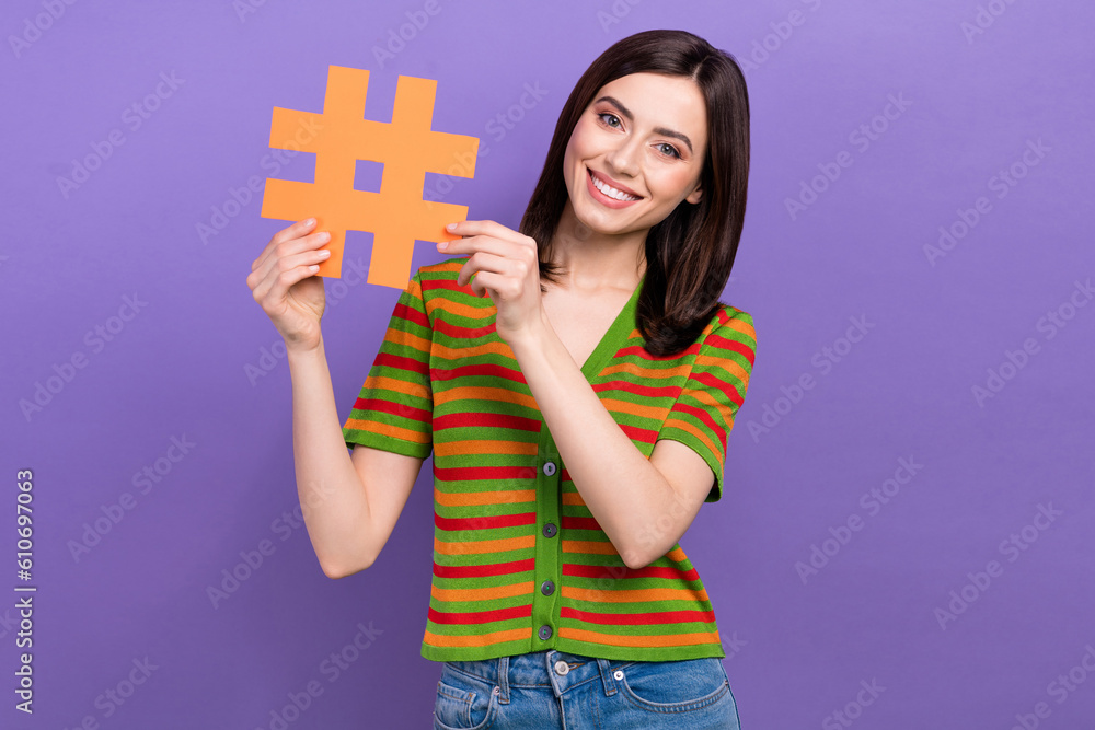 Portrait of adorable gorgeous lady wear stylish clothes hand hold hashtag promote online shop isolated on purple color background Portrait of adorable gorgeous lady wear stylish clothes hand hold hashtag promote online shop isolated on purple color background