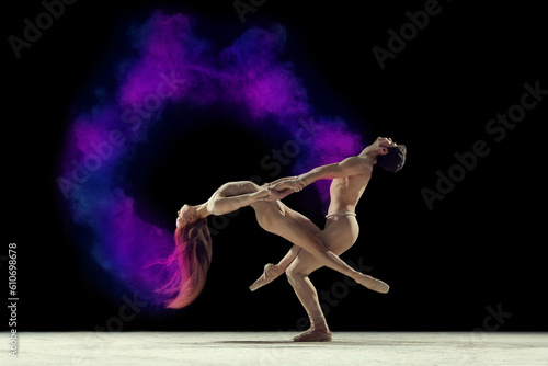 Fototapeta Naklejka Na Ścianę i Meble -  Expressive dance. Young man and woman, ballet dancers making performance with powder explosion against black studio background. Concept of art, festival, beauty of dance, inspiration, youth