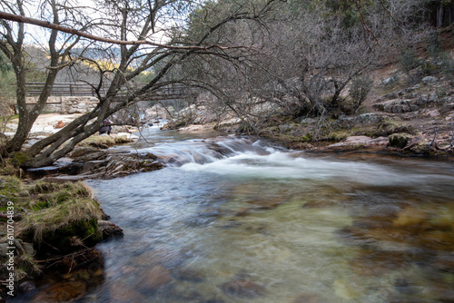 Fotografía de un paisaje impresionante: Una imagen panorámica que muestra las majestuosas montañas de La Pedriza y su río serpenteante en primer plano. 