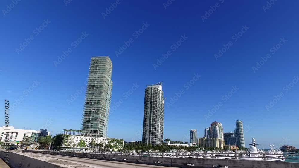 Pov Panning Shot Of Vehicles On Bridge Near Skyscrapers In City Against Clear Blue Sky - Miami, Florida Pov Panning Shot Of Vehicles On Bridge Near Skyscrapers In City Against Clear Blue Sky - Miami, Florida