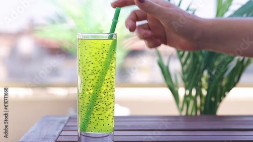 Refreshing drink with basil seeds. Detox cocktail. A woman's hand takes a drink with basil seedsA chia seed drink . Healthy food. Summer drinks. photo