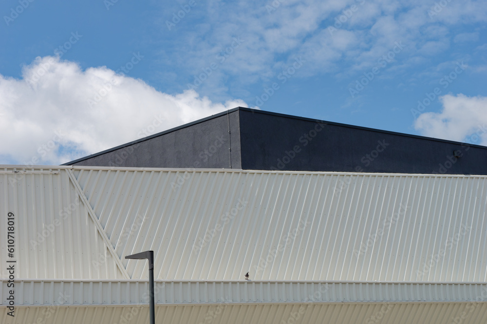 Minimalistic photo of an exterior of a modern tin building with a sky in the background	
