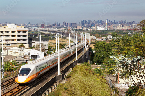 Wallpaper Mural 
A train of Taiwan High Speed Rail (THSR) traveling through a railway curve in the countryside with modern skyscrapers of Taichung City in the distant background under blue sunny sky Torontodigital.ca