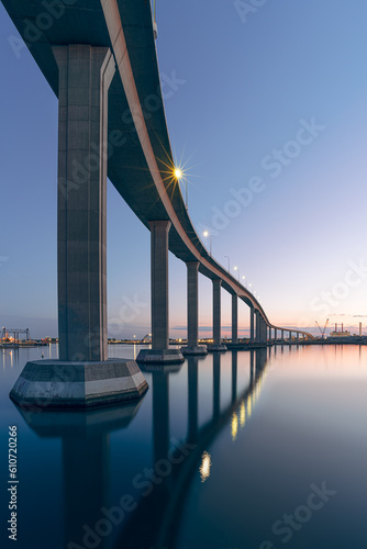 The Jordan Bridge over the Elizabeth River on the border of Norfolk and Chesapeake Virginia against a beautiful red, purple, pink, and blue sunset	
