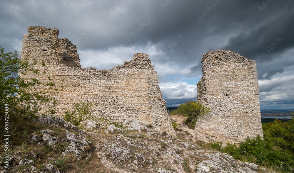 castle ruins on a rock with a background of dramatic dark clouds