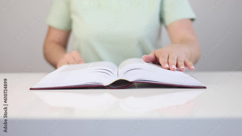 A woman is reading a book in a bright room. A woman is reading a book in a bright room.