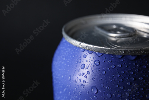 Lilac can of fresh soda with water drops on dark background, closeup