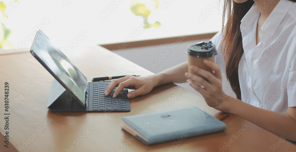 Fototapeta premium Portrait of Asian young female working on laptop at office