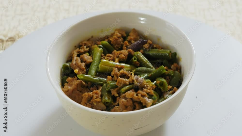 Green beans with meat traditional jewish dish in a plate rotate in a circle. Close-up. Green beans with meat traditional jewish dish in a plate rotate in a circle. Close-up.