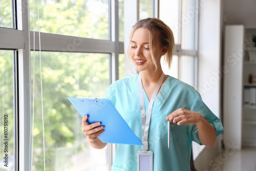 Female medical intern with clipboard in clinic