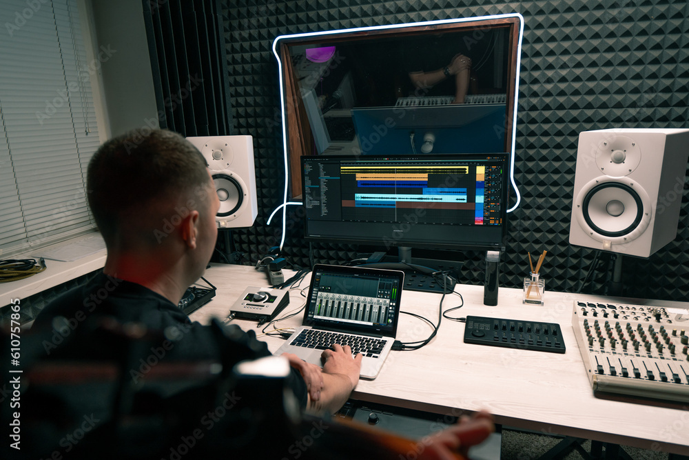 Fototapeta premium rock performer with electric guitar in recording studio recording playing own track with sound engineer creating song