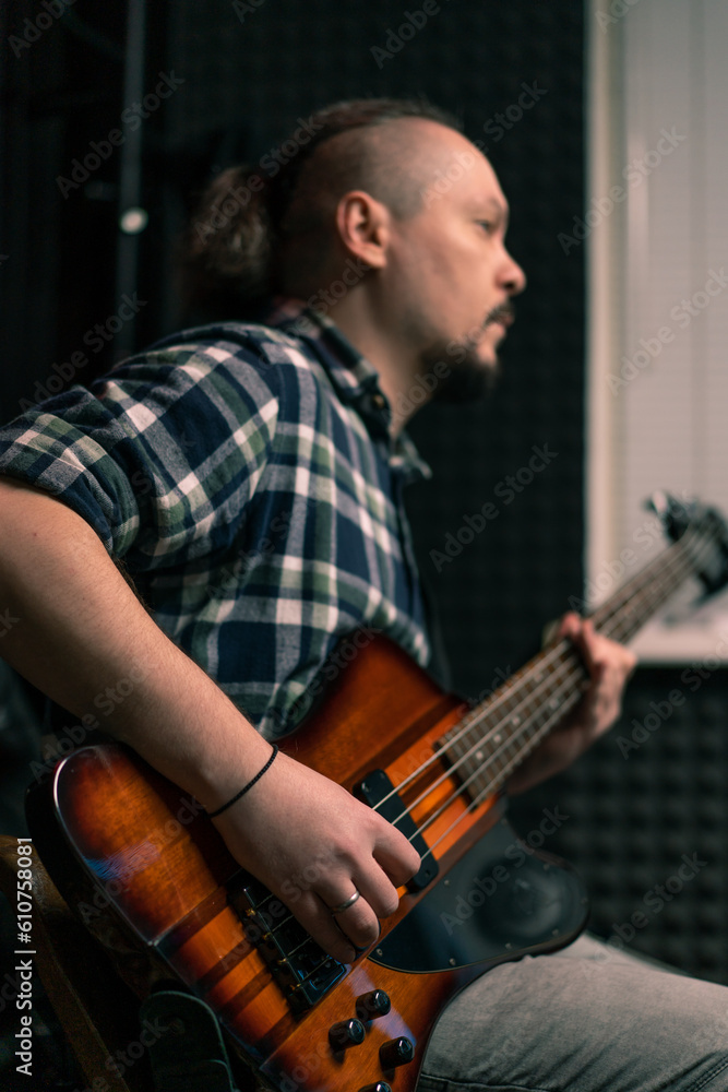 Obraz premium rock performer with electric guitar in recording studio recording playing own track musical instrument strings melody