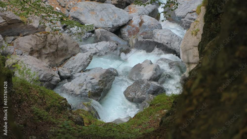 Water flowing around stones. River in the mountains. Linth River, Linthal, Canton of Glarus, Switzerland Water flowing around stones. River in the mountains. Linth River, Linthal, Canton of Glarus, Switzerland