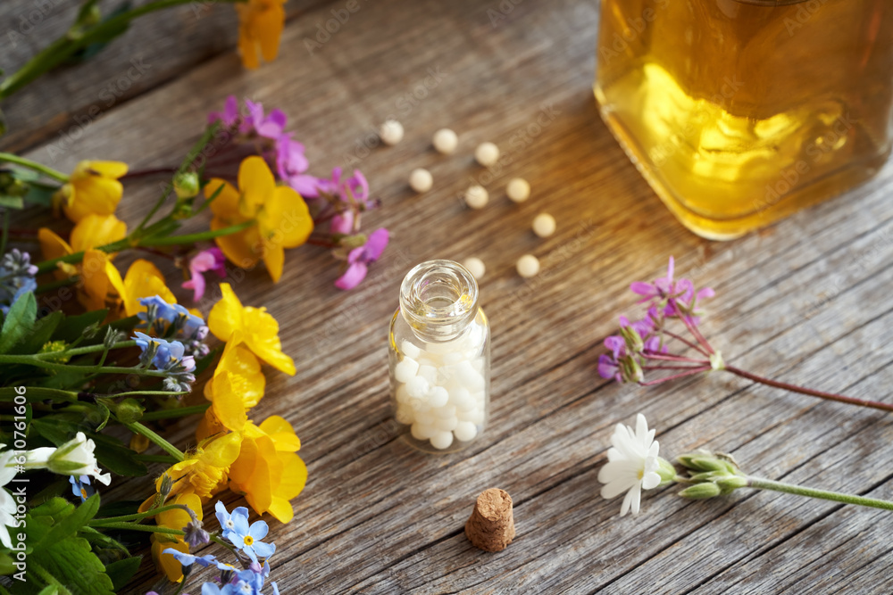 Obraz premium Homeopatic pills in a bottle with fresh flowers