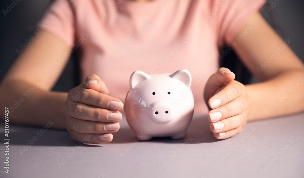women holding a piggy bank and coin women holding a piggy bank and coin