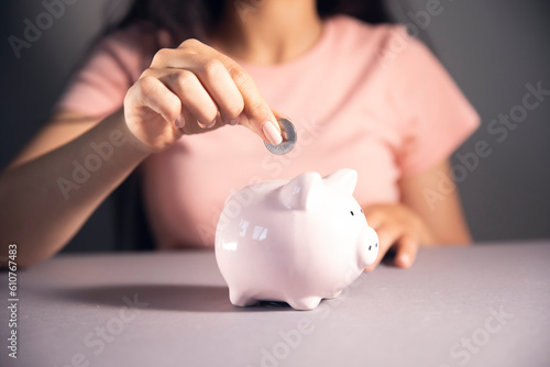 women holding a piggy bank and coin
