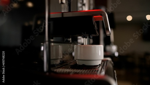 Close-up of pouring espresso. Professional coffee making. The coffee machine is pouring coffee.