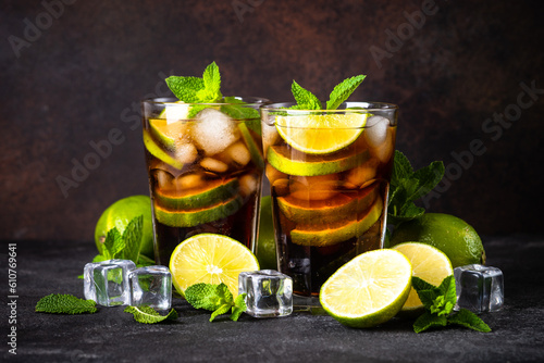 Cuba Libre alcoholic cocktail, iced drink on dark background.