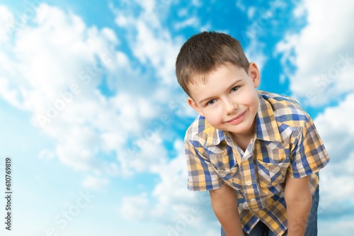 Happy Child standing on blue sky background.