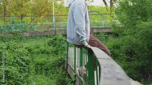 A girl sits on pirals on a bridge photo