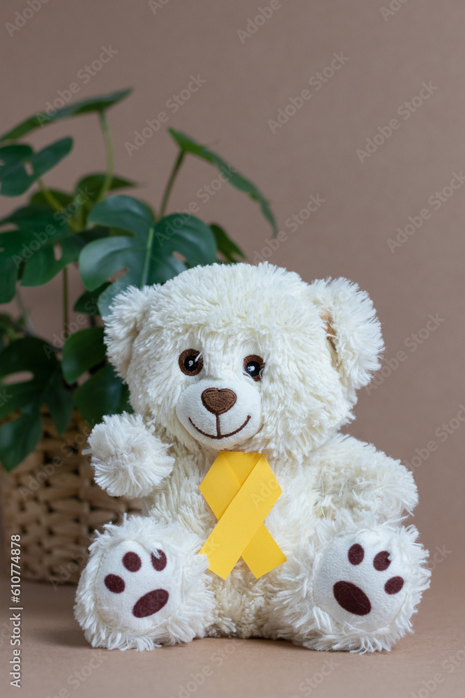 Toy bear with a yellow ribbon on a nude background. Toy bear with a yellow ribbon on a nude background.