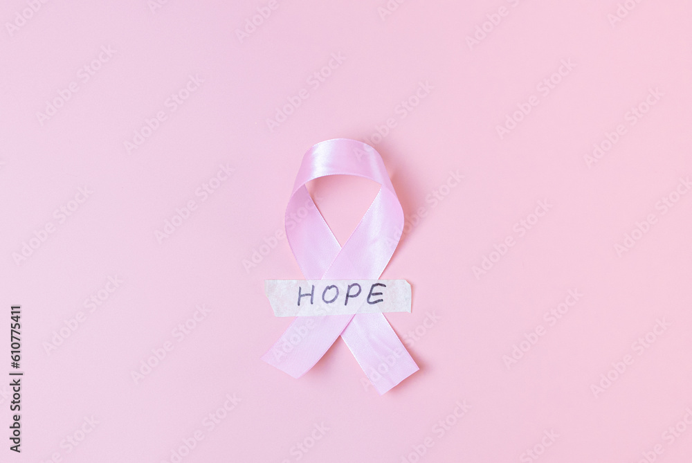 Pink ribbon with sticky tape and the word: hope on a pink background. Pink ribbon with sticky tape and the word: hope on a pink background.