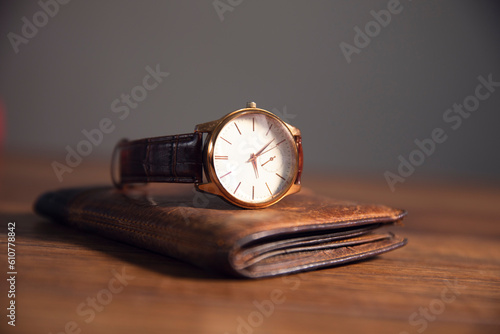 brown watch in brown wallet on the wooden table