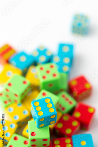 Pile of Multi-Colored Dice on a White Background  Blue Dice with Six Pips on Top in Focus