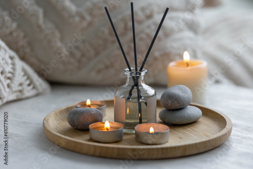Burning candles, aroma fragrance natural organic diffuser, wooden bamboo tray. Concept of cozy home space for meditation, relaxation, detention. Spiritual aura cleansing routine for full moon ritual