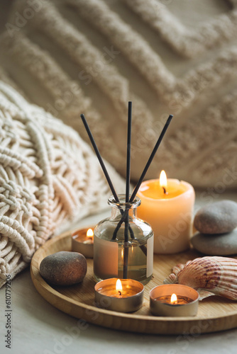 Burning candles on bamboo tray  cozy home atmosphere. Relaxation  detention zone in the living or bedroom. Stones  sea shells as decor. Apartment natural aroma diffusor with ocean breeze fragrance.