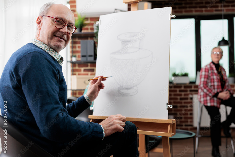 Fotografie Happy senior man attending art workshop
